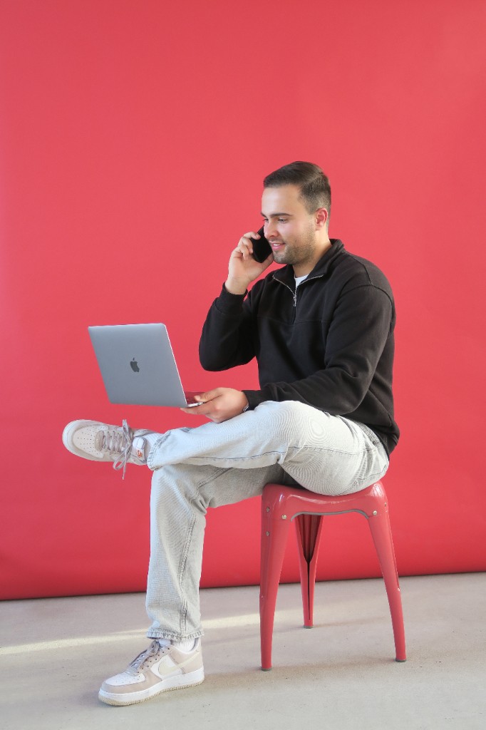 Remote closer die vanaf een flexibele werkplek een salesgesprek voert via laptop en telefoon